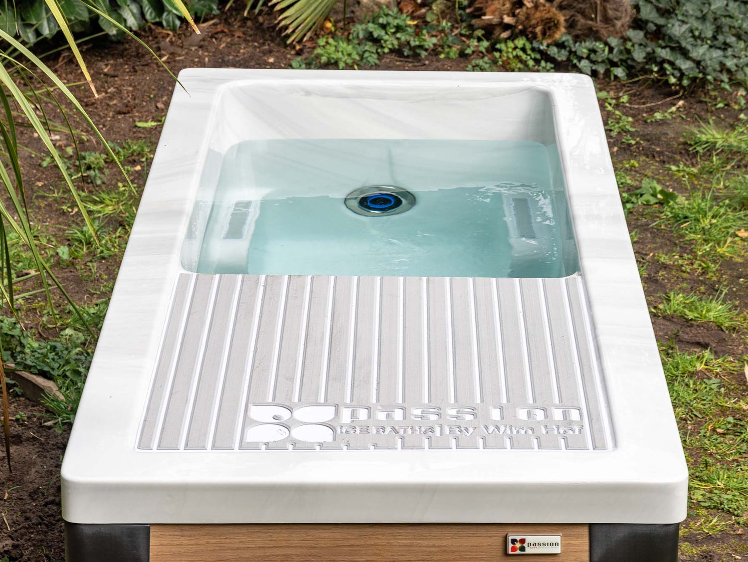 Modern white Breeze ice bath with current system filled with blue-tinted water, featuring ribbed drainage platform - Passion Ice Baths Collection