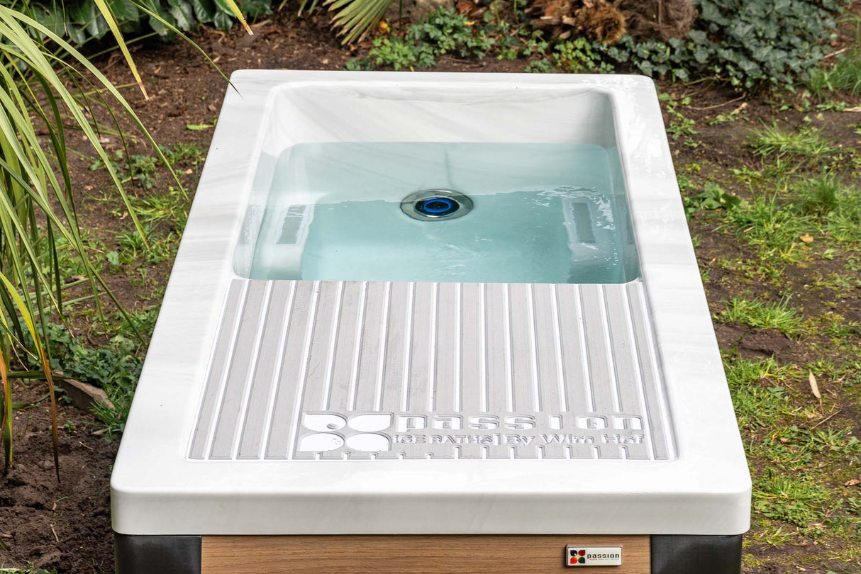 Modern white Breeze ice bath with current system filled with blue-tinted water, featuring ribbed drainage platform - Passion Ice Baths Collection