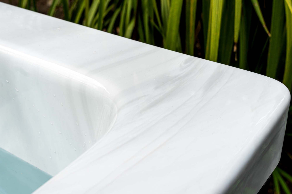 Modern white Breeze ice bath with current system shown against natural green foliage, highlighting sleek rim design - Passion Ice Baths Collection