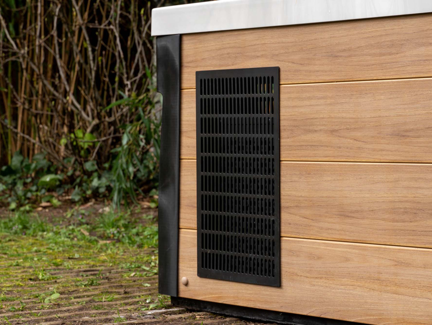 Modern Breeze ice bath with black ventilation panel on wood-grain exterior panel, showcasing current system - Passion Ice Baths