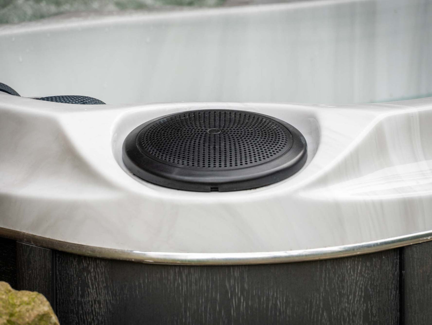 Circular black speaker detail on white Elevate ice bath surface, showcasing premium audio features - Passion Ice Baths Collection