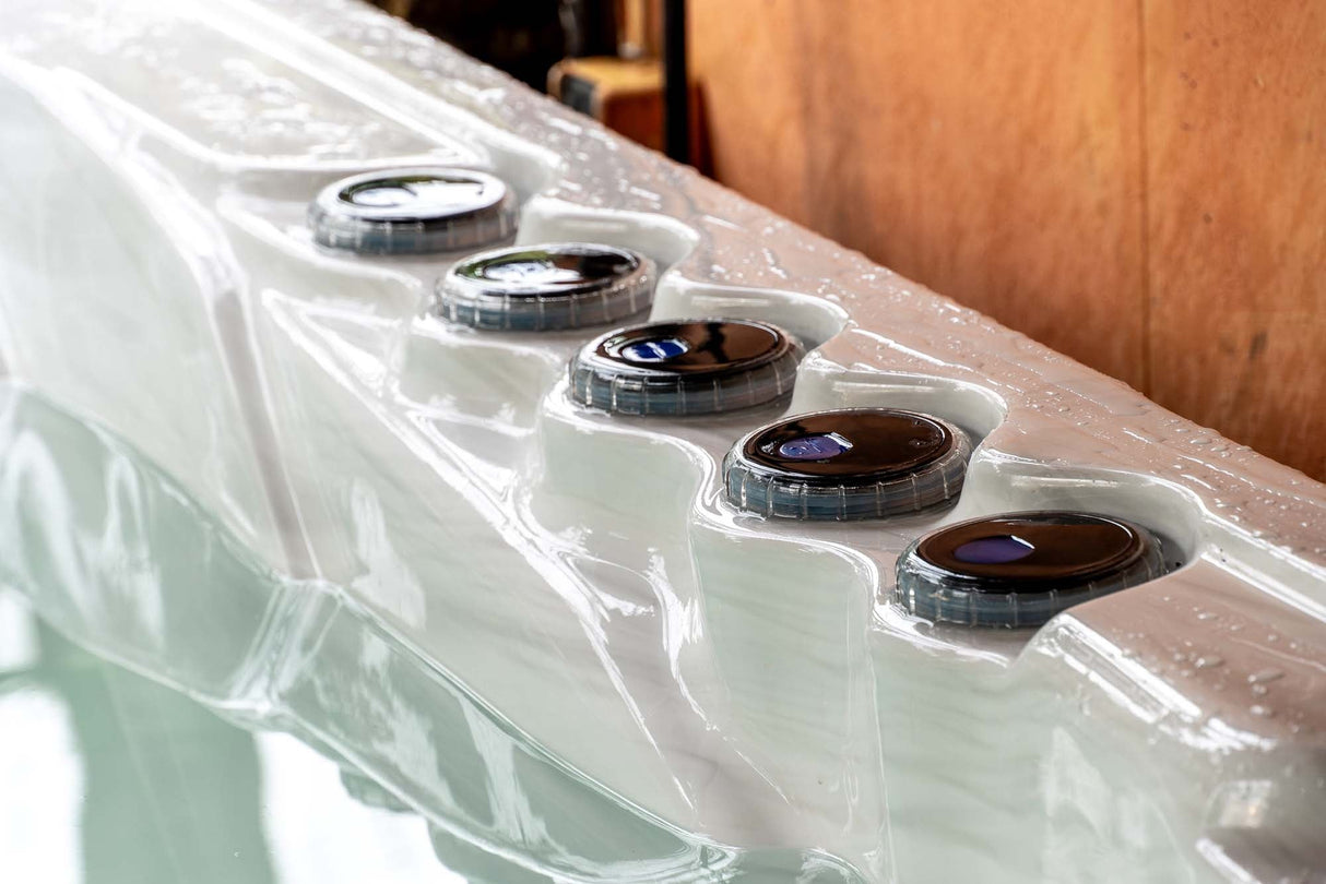 Elevate ice bath with five circular control panels on white acrylic edge, featuring LED-lit jets by Passion Ice Baths