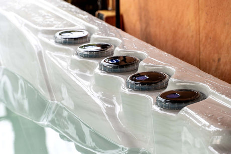 Elevate ice bath with five circular control panels on white acrylic edge, featuring LED-lit jets by Passion Ice Baths