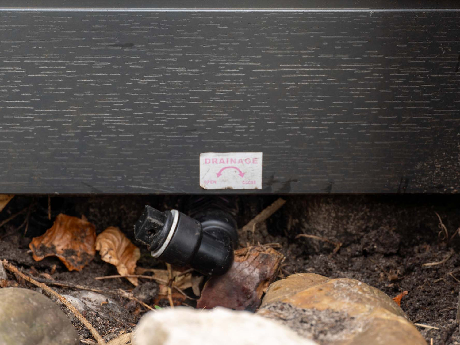 Drainage system detail with black pipe and rocks beneath Elevate ice bath by Passion Ice Baths