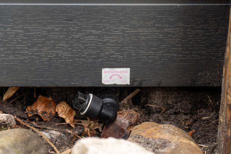 Drainage system detail with black pipe and rocks beneath Elevate ice bath by Passion Ice Baths