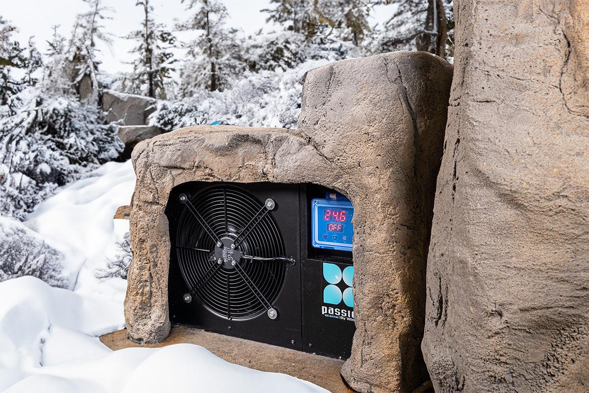 Rock-inspired outdoor ice bath 'Faith' with integrated cooling system nestled in snowy winter landscape - Passion Ice Baths Ice bath collection