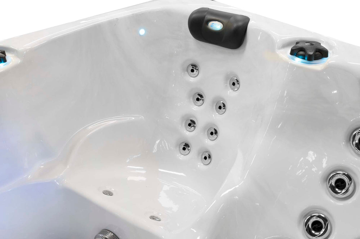 Interior view of Renew 3-person hot tub showing ergonomic seating and therapeutic massage jets in white acrylic shell - Passion Spas Pure Collection