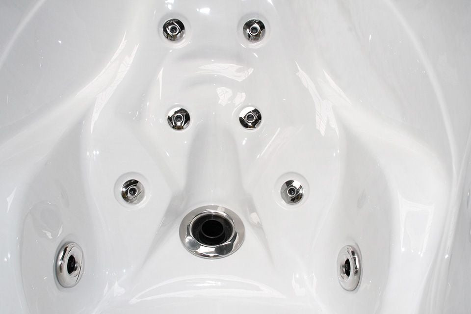 Bliss spa interior close-up showing chrome hydrotherapy jets and drain in white acrylic shell - Passion Spas Signature Collection Hot Tub