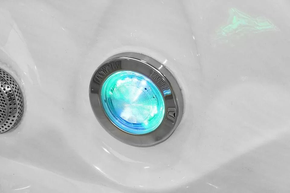 Pleasure hot tub StarBrite LED light detail in turquoise blue, chrome-rimmed jet feature - Passion Spas Signature Collection